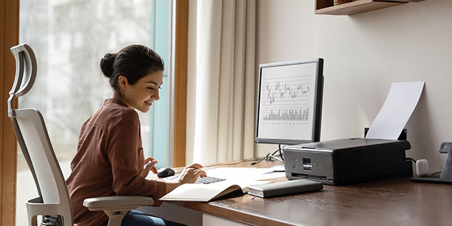 A young woman working at a desk with her computer.