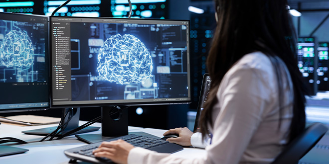 A young woman designing AI on a desktop computer