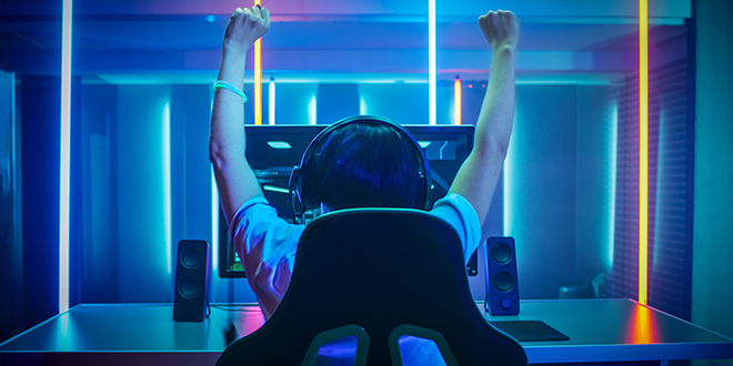 Um jovem a celebrar uma vitória num jogo de PC